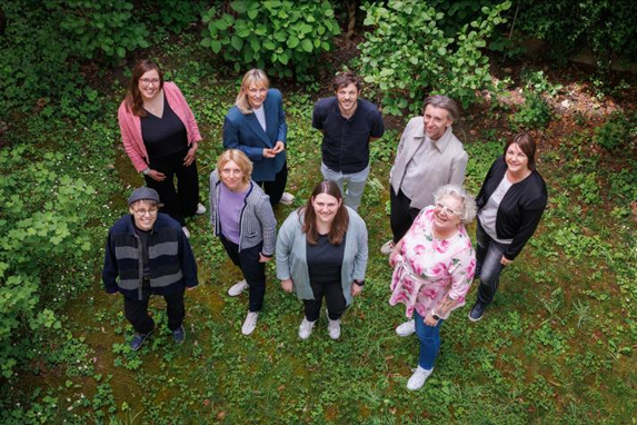 Das Bild zeigt einen Schreibtisch mit orangener Oberfläche, die Tastatur eines Laptops, einen Taschenrechner sowie einen Block mit Bleistift